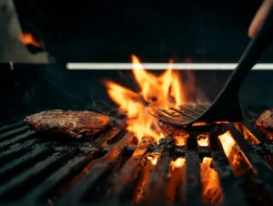 Burger cooking over flames on an outdoor barbecue grill